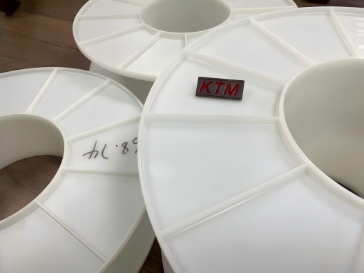 White ribbed plastic reel flanges with KTM identification